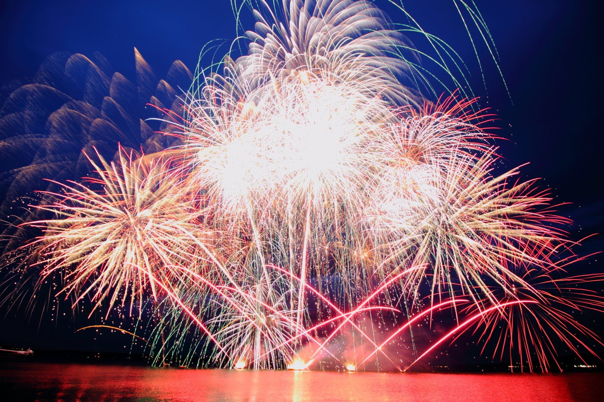 A large fireworks display over a body of water For Rotorua Glo Festival 