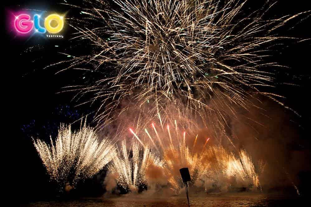 A fireworks display with the word glo glowing in the background