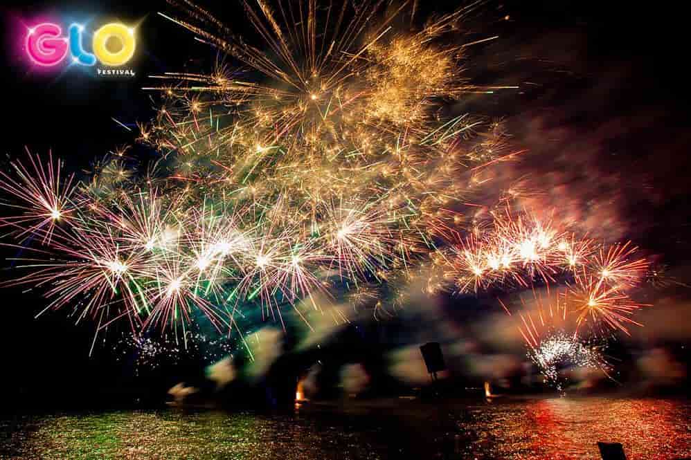 A bunch of fireworks are going off over a body of water.