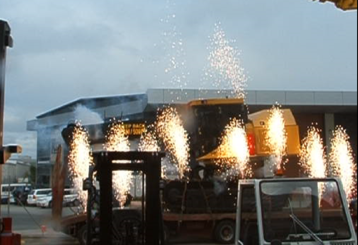 A forklift and a bulldozer are surrounded by fireworks