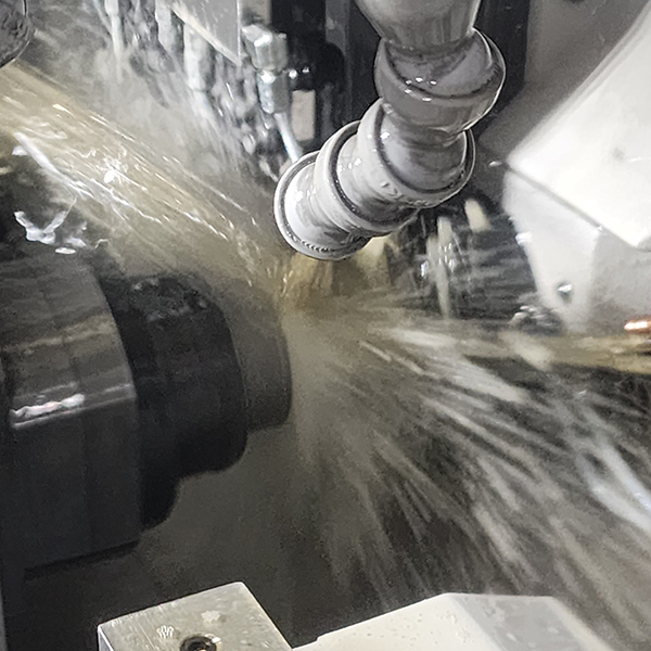 Machining process with liquid coolant spraying onto a metal part.