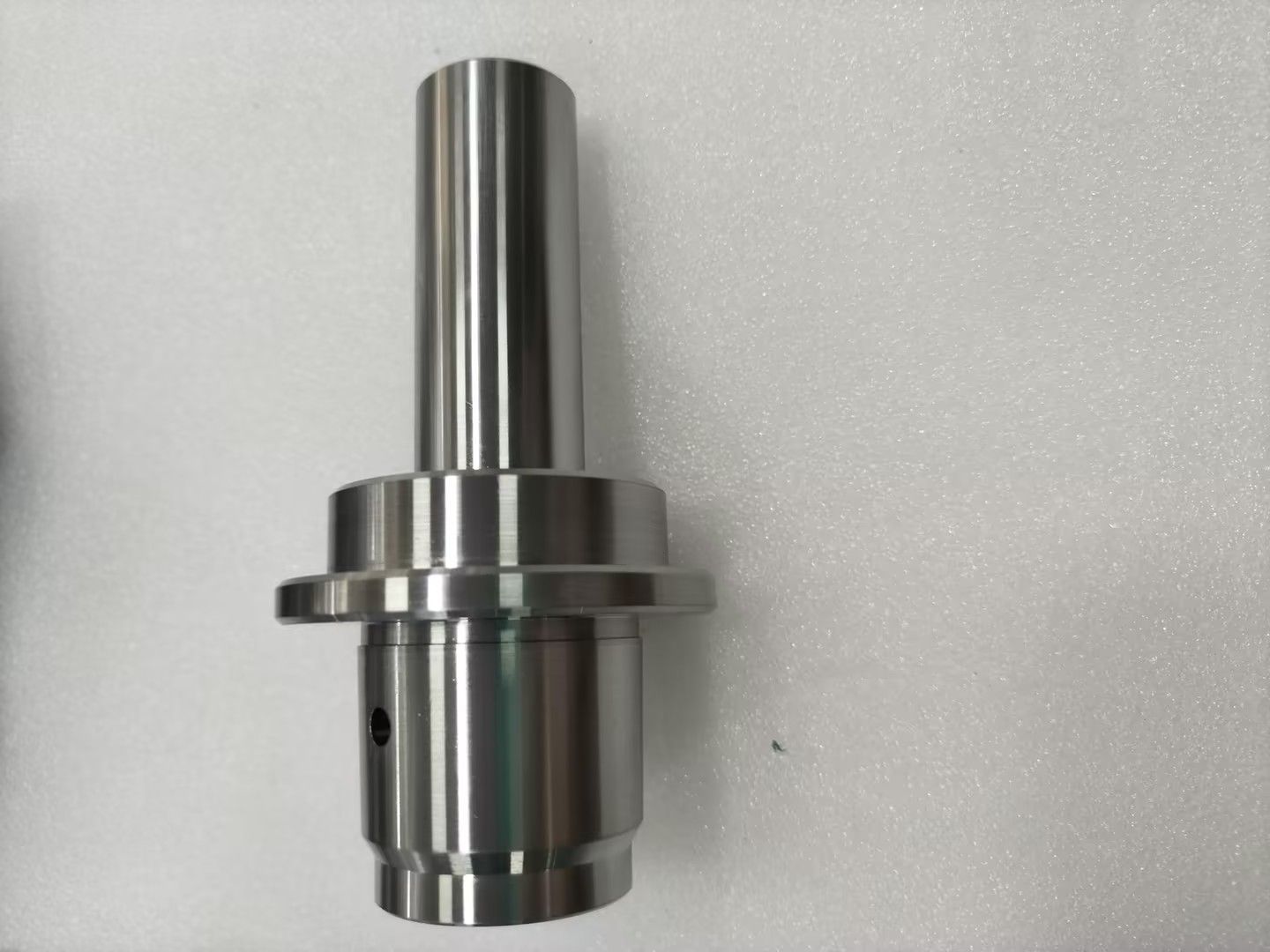 CNC machine milling a metal gear. Close-up with coolant hoses visible.