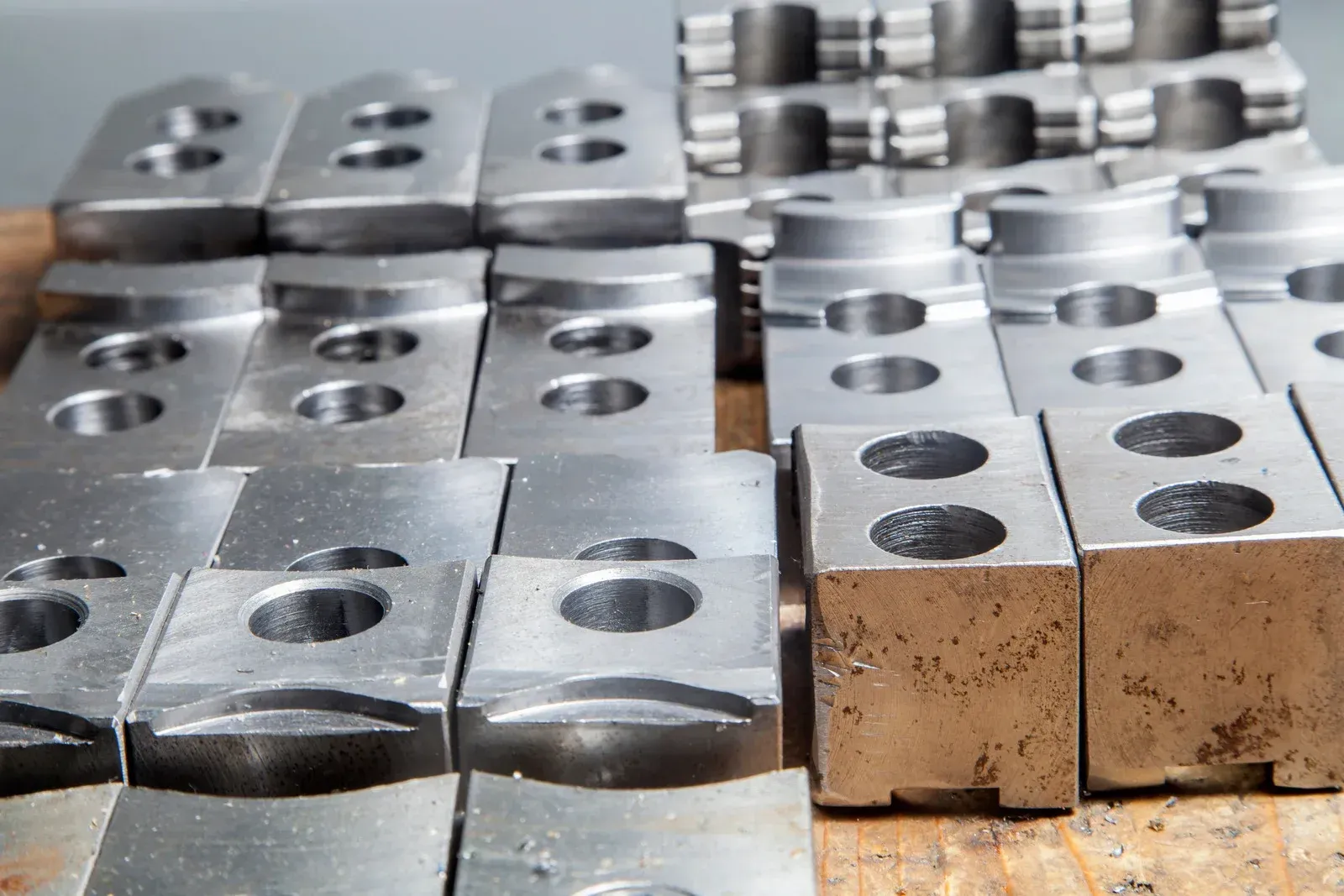 Person aiming a handgun at a shooting range target. Wearing earmuffs and safety glasses.