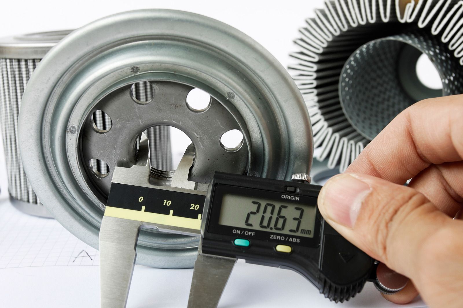 CNC machine milling a metal gear. Close-up with coolant hoses visible.