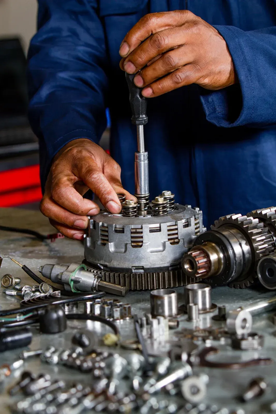 CNC machine milling a metal gear. Close-up with coolant hoses visible.
