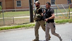 Police walk near Robb Elementary School following a shooting