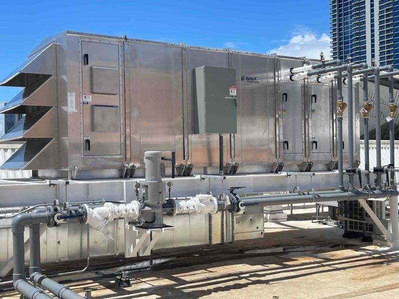 Industrial rooftop HVAC unit under a bright blue sky with clouds Industrial rooftop HVAC unit under a bright blue sky with clouds