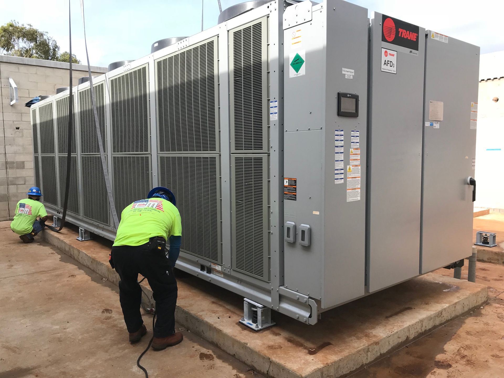 Rooftop HVAC units beside white buildings, with large metal ventilation fans and reflective wet pavement. Rooftop HVAC units beside white buildings, with large metal ventilation fans and reflective wet pavement.