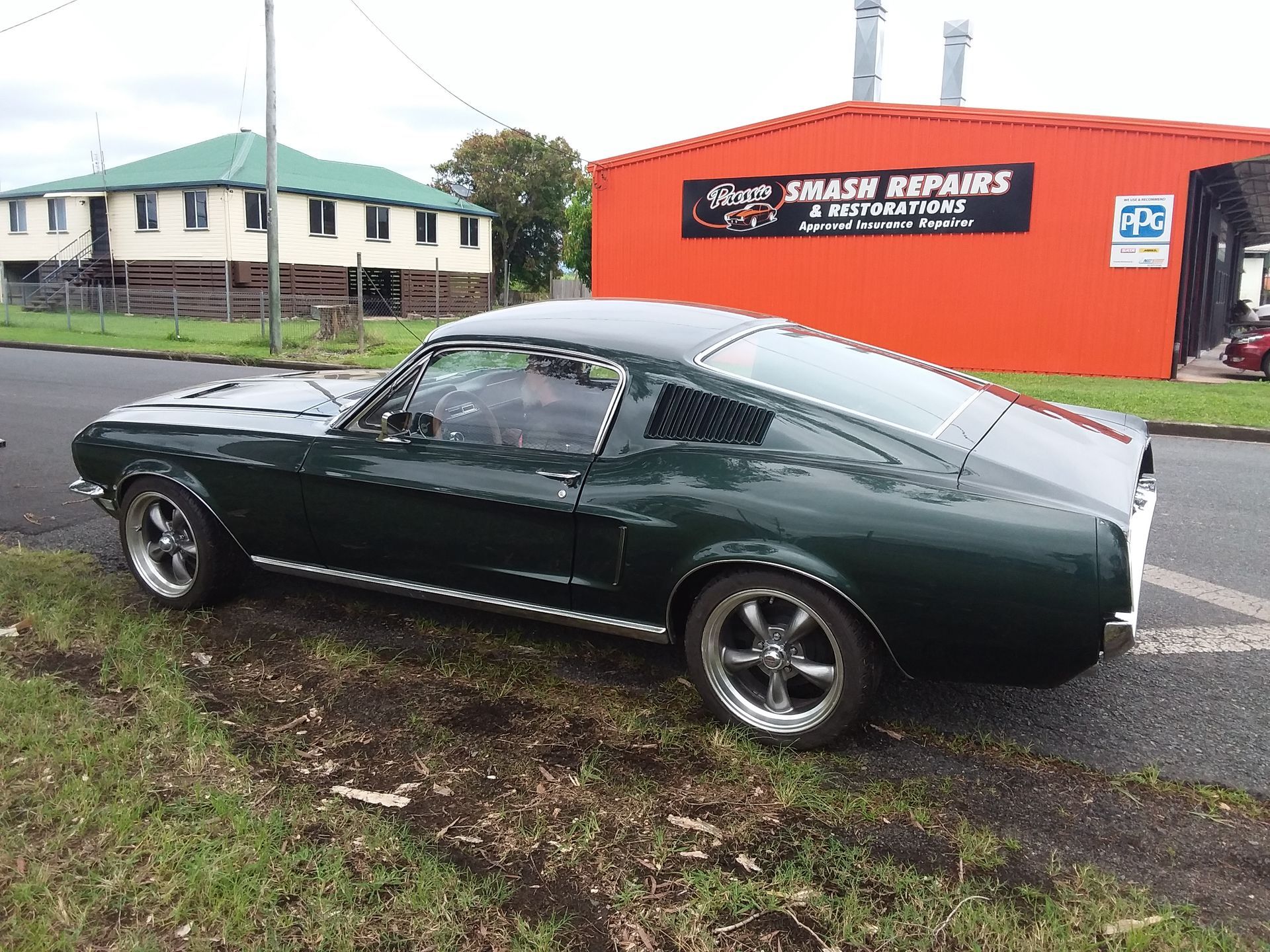 A Man Wearing A Branded Shirt is working on a car — Proserpine Smash Repairs & Restorations In Proserpine, QLD