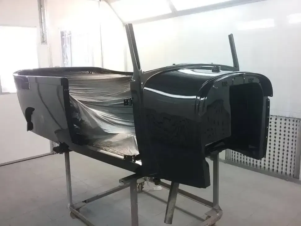 A Black Car Is Being Painted In A Paint Booth — Proserpine Smash Repairs & Restorations In Proserpine, QLD