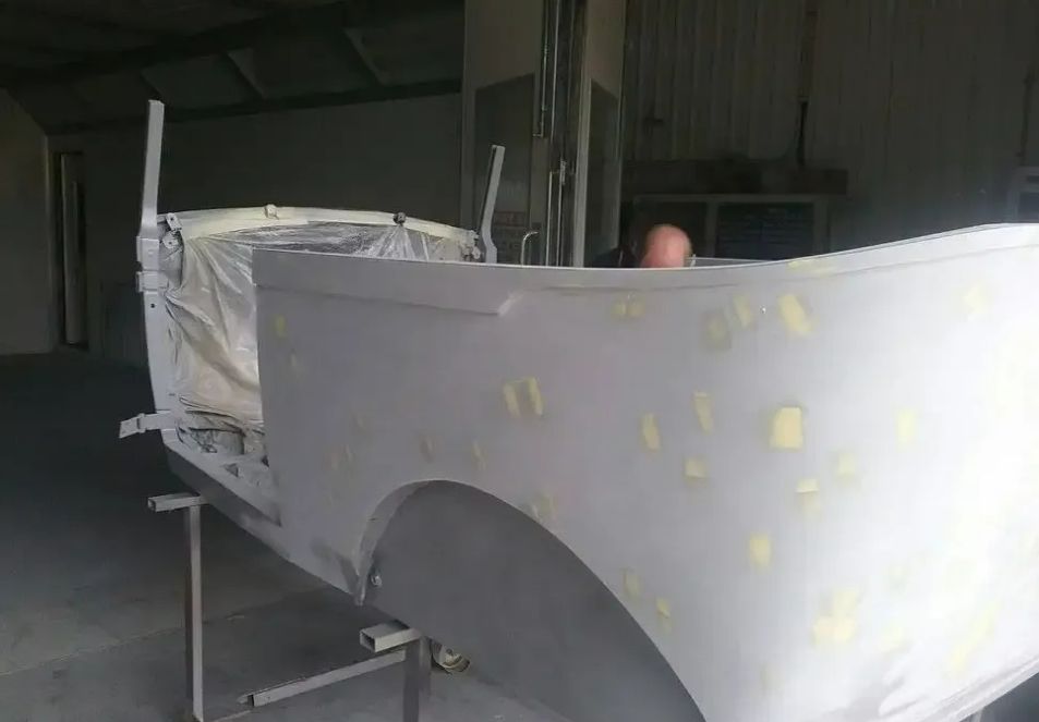 A White Car Is Being Painted In A Garage — Proserpine Smash Repairs & Restorations In Proserpine, QLD