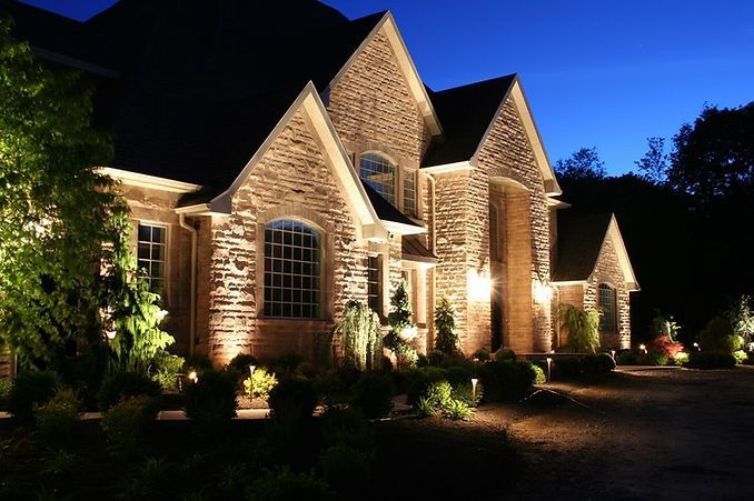 A large brick house is lit up at night.