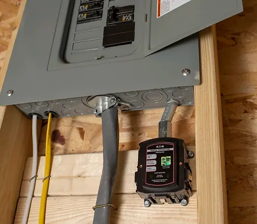 A electrical box is mounted on a wooden wall.