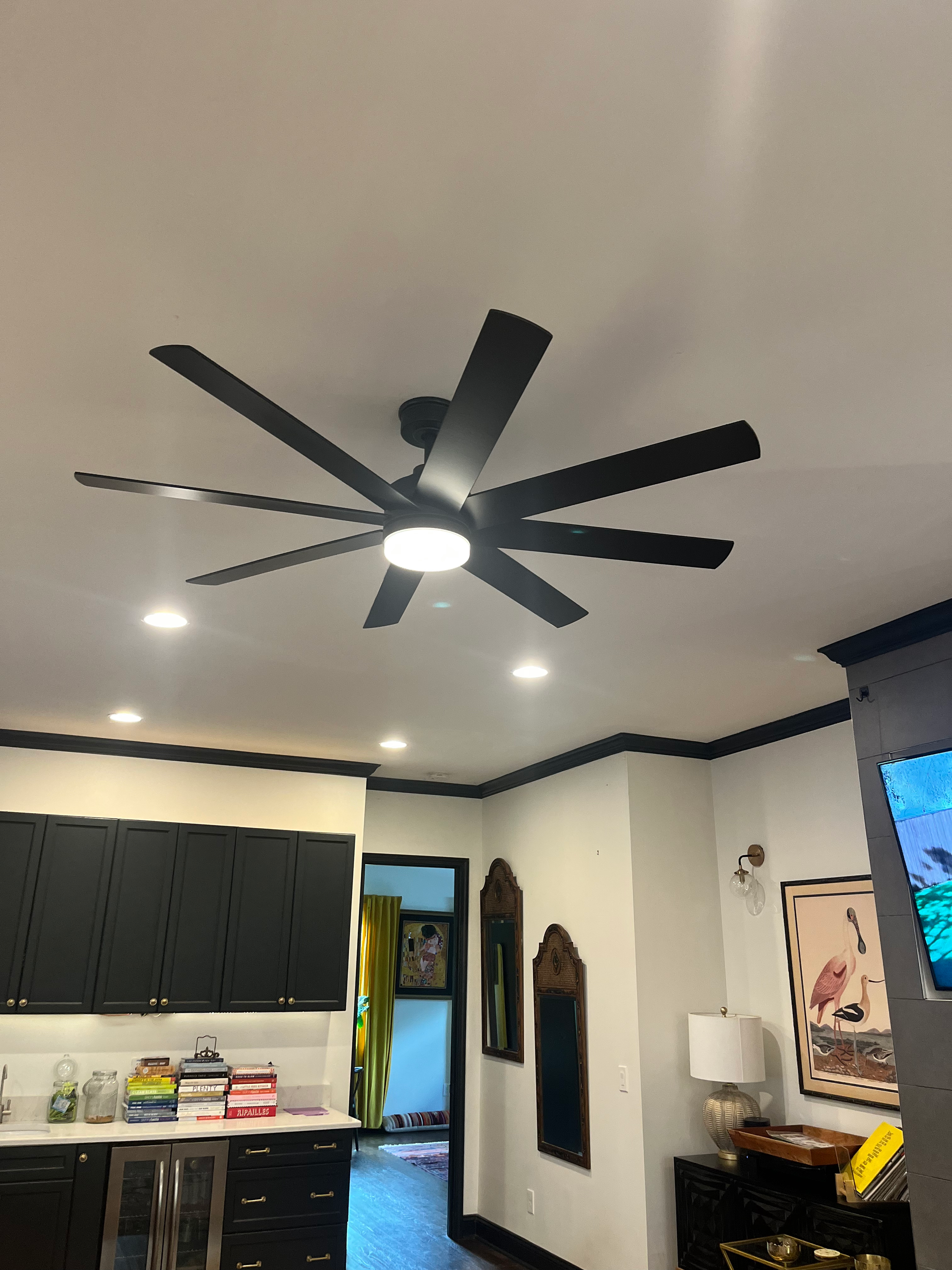 A ceiling fan is hanging from the ceiling of a living room.