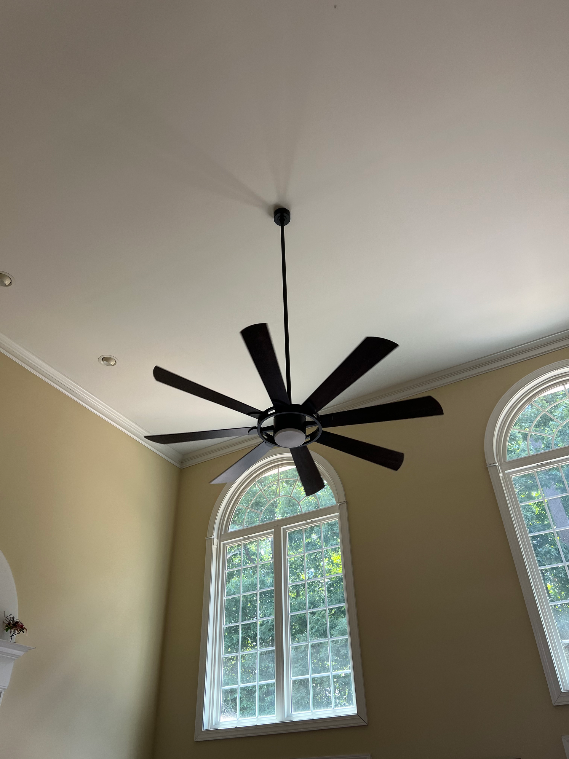 A ceiling fan is hanging from the ceiling in a room with a window.