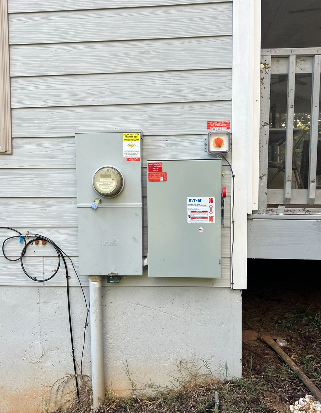 An electrical box is installed on the side of a house.