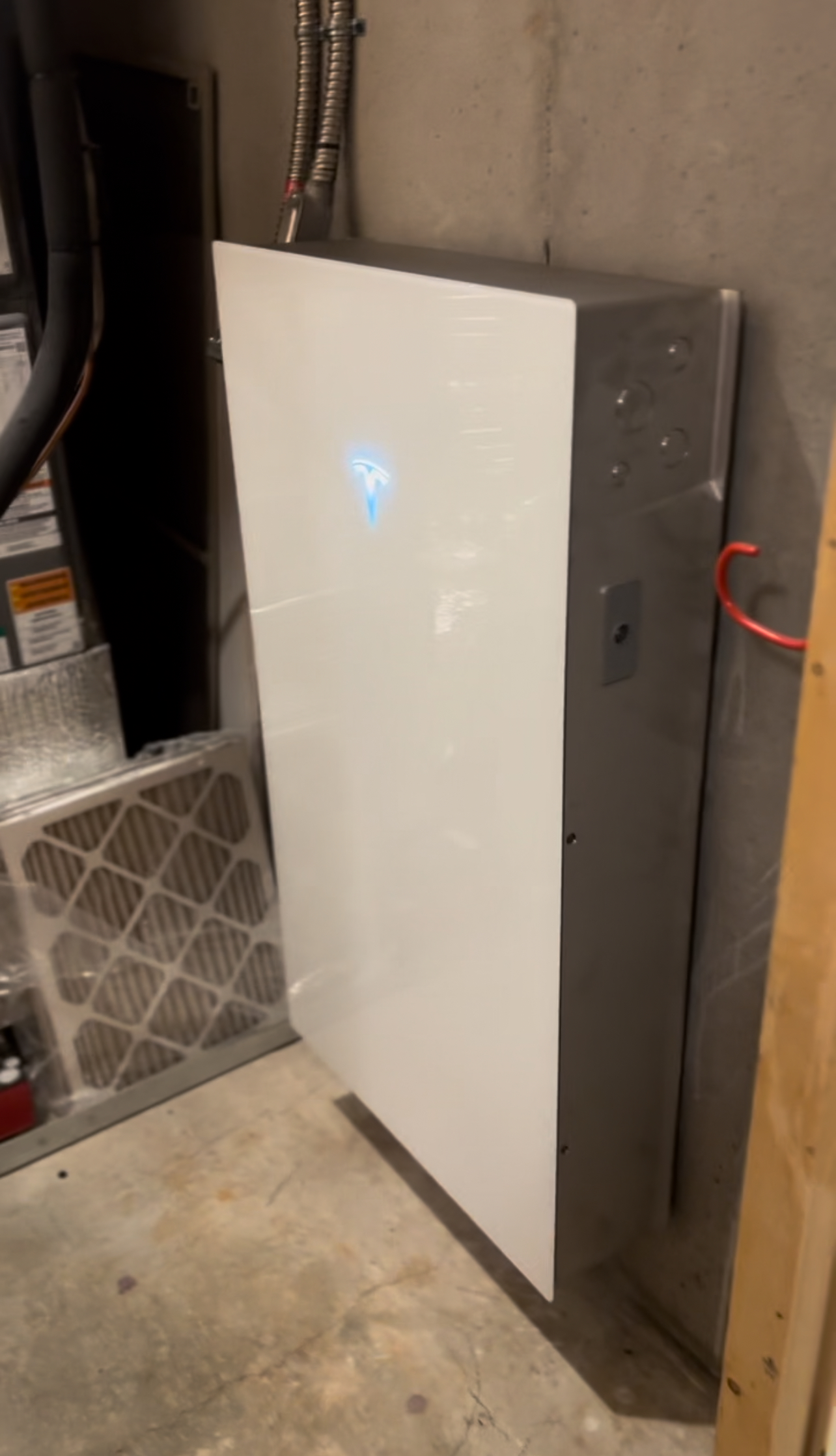 A white box is sitting on a concrete floor next to a wall.