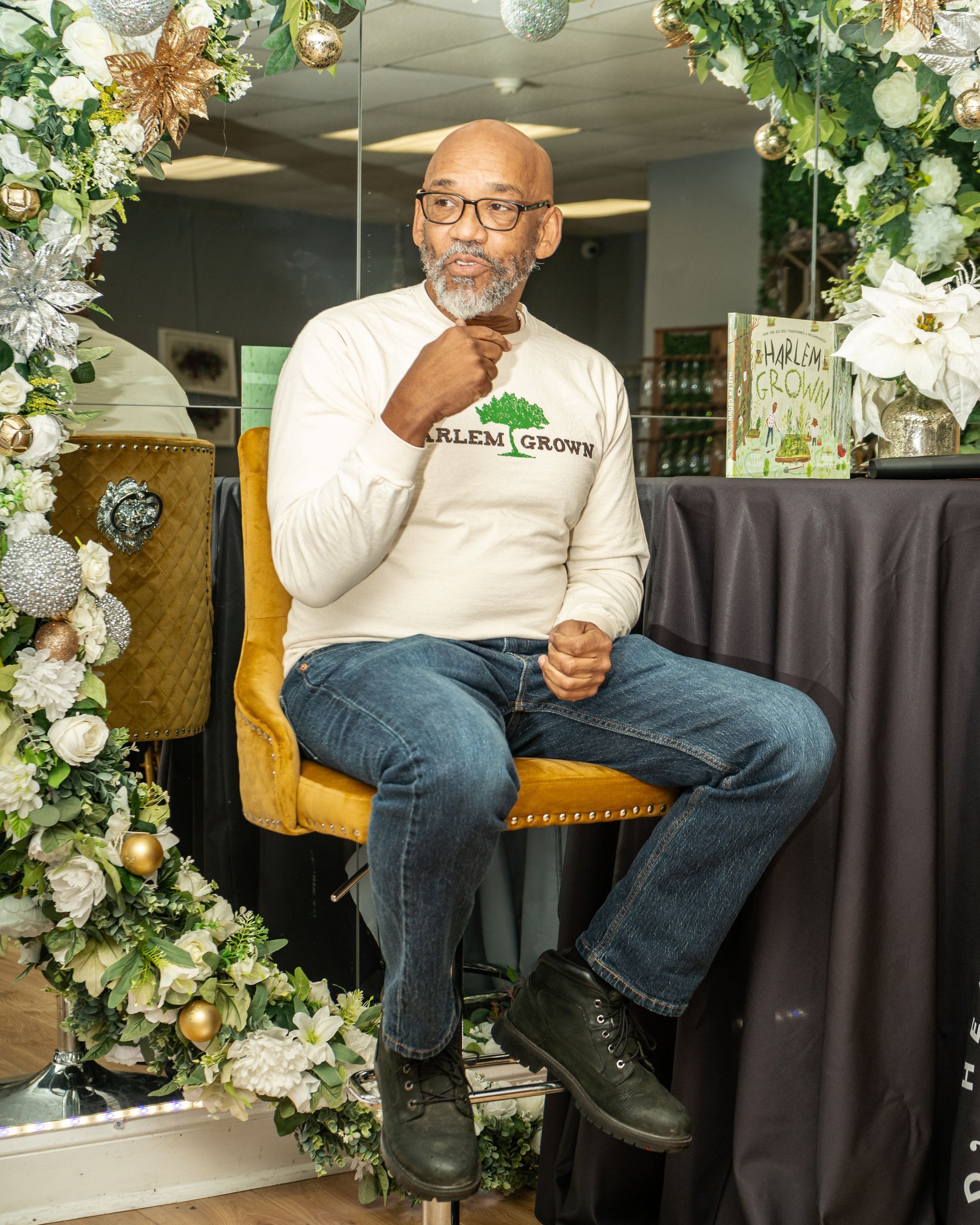 A man is sitting in a chair in front of a christmas tree.