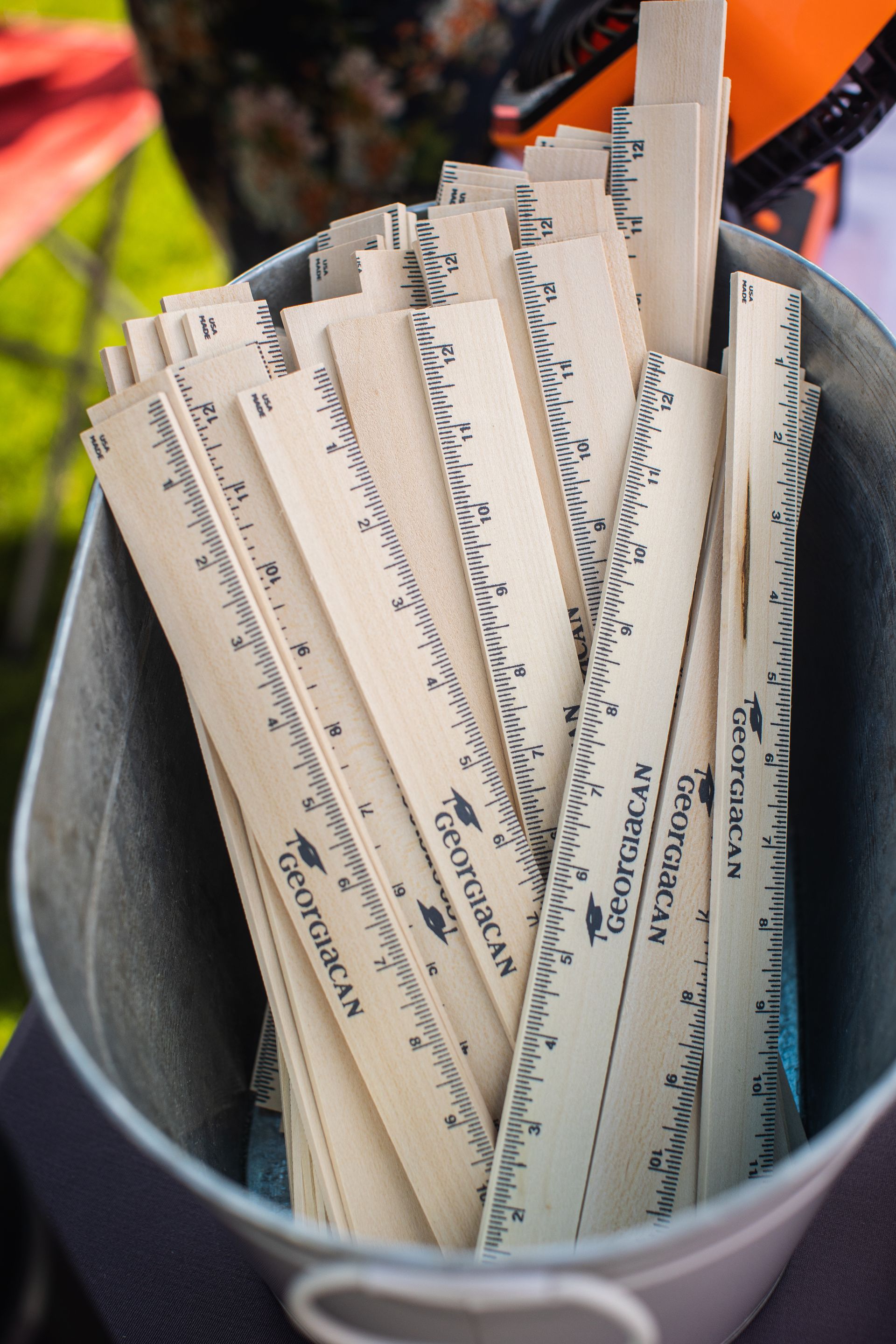 A metal bucket filled with wooden rulers with the word georgia on them