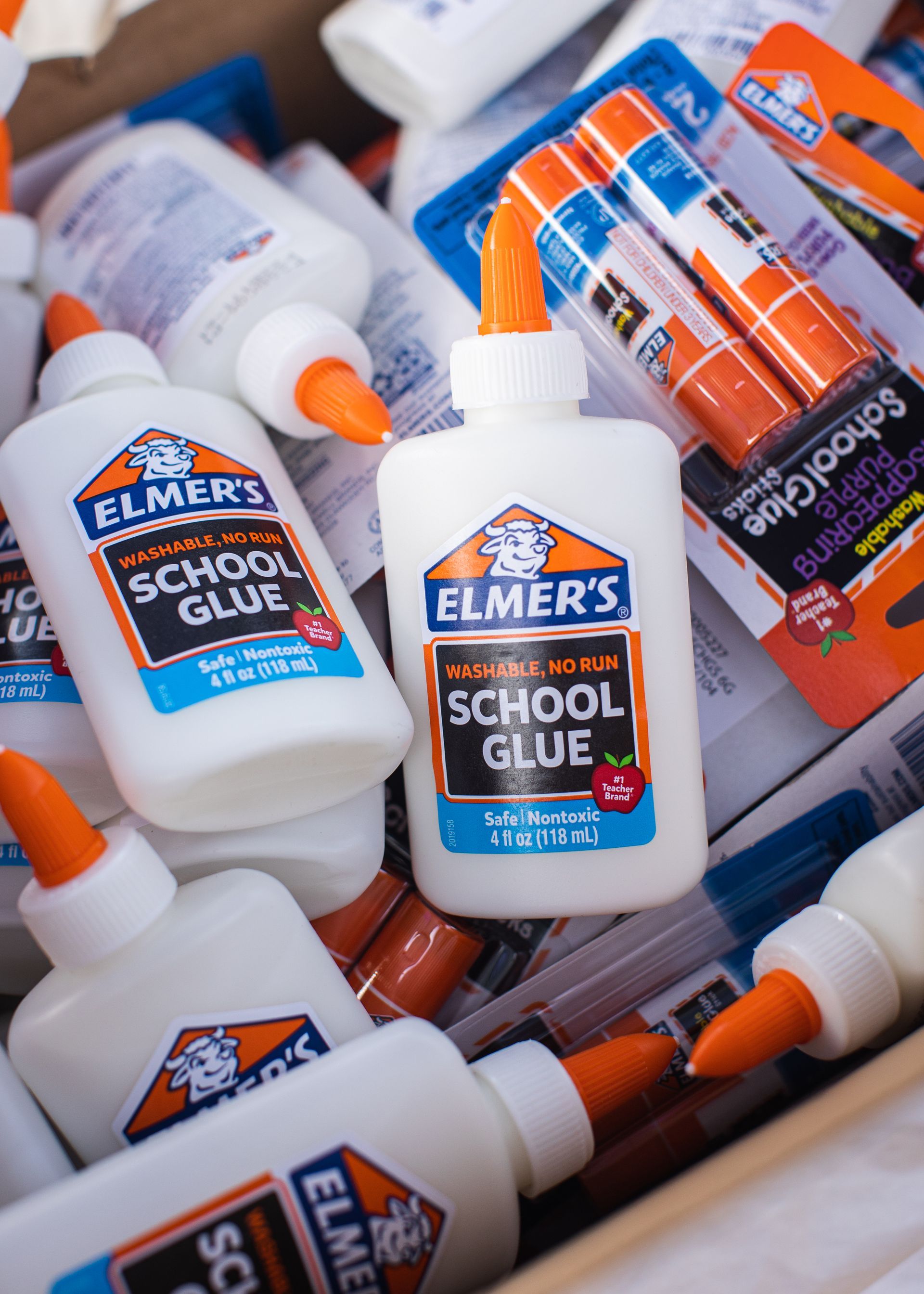 Bottles of elmer 's school glue are stacked on top of each other