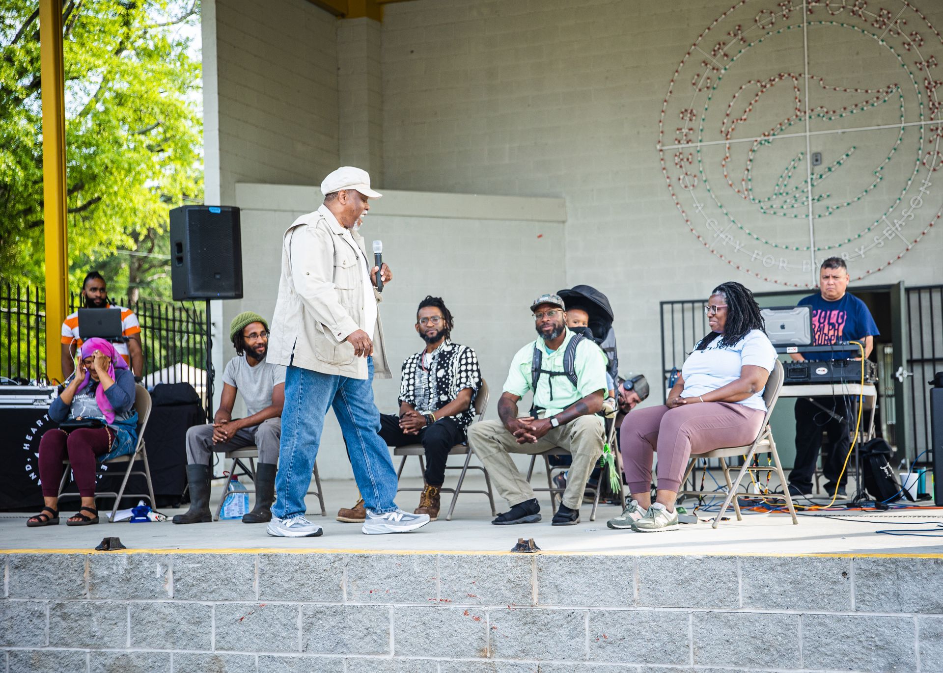 A group of people are sitting and standing on a stage.