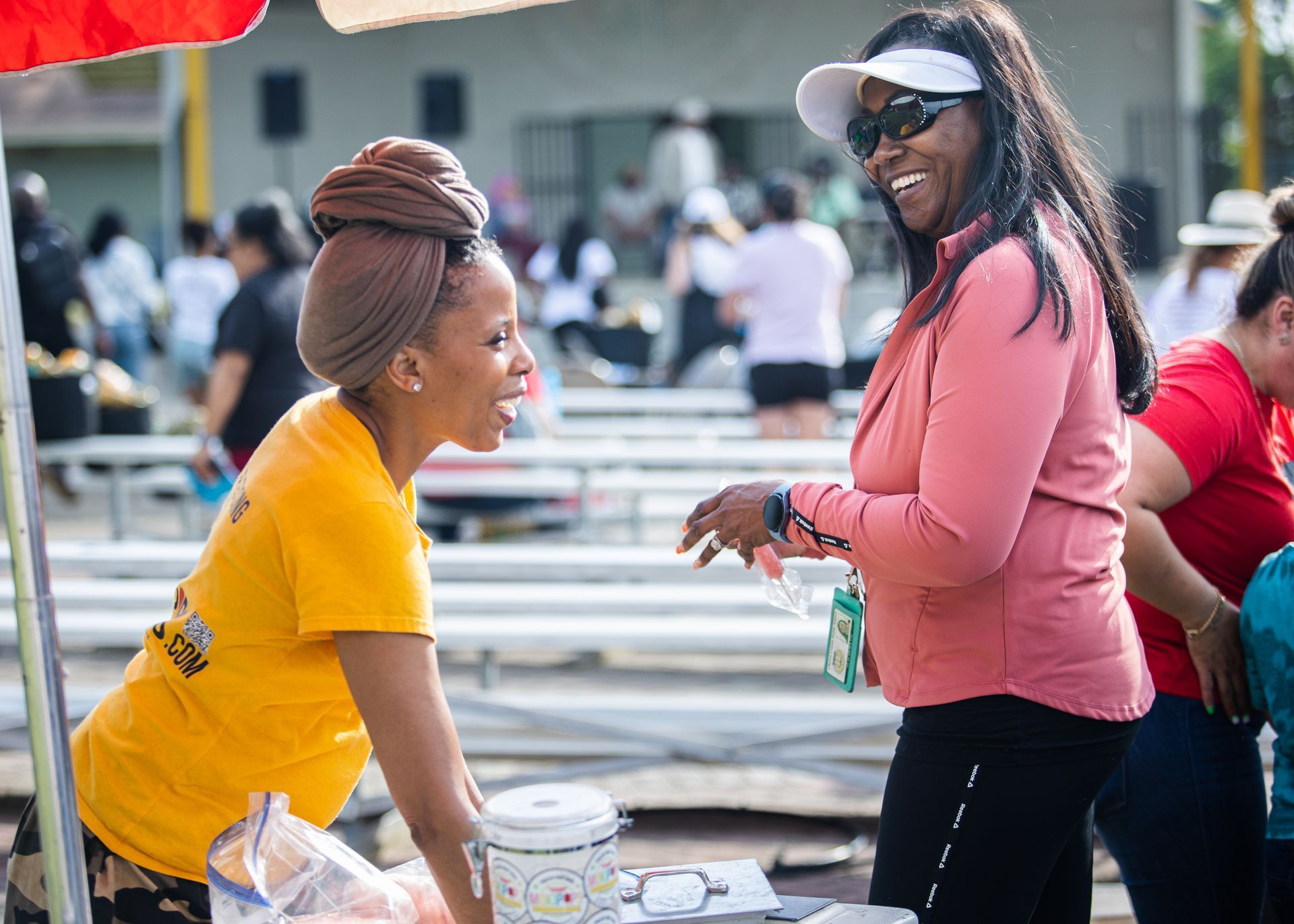 Two women are talking to each other at a picnic table.