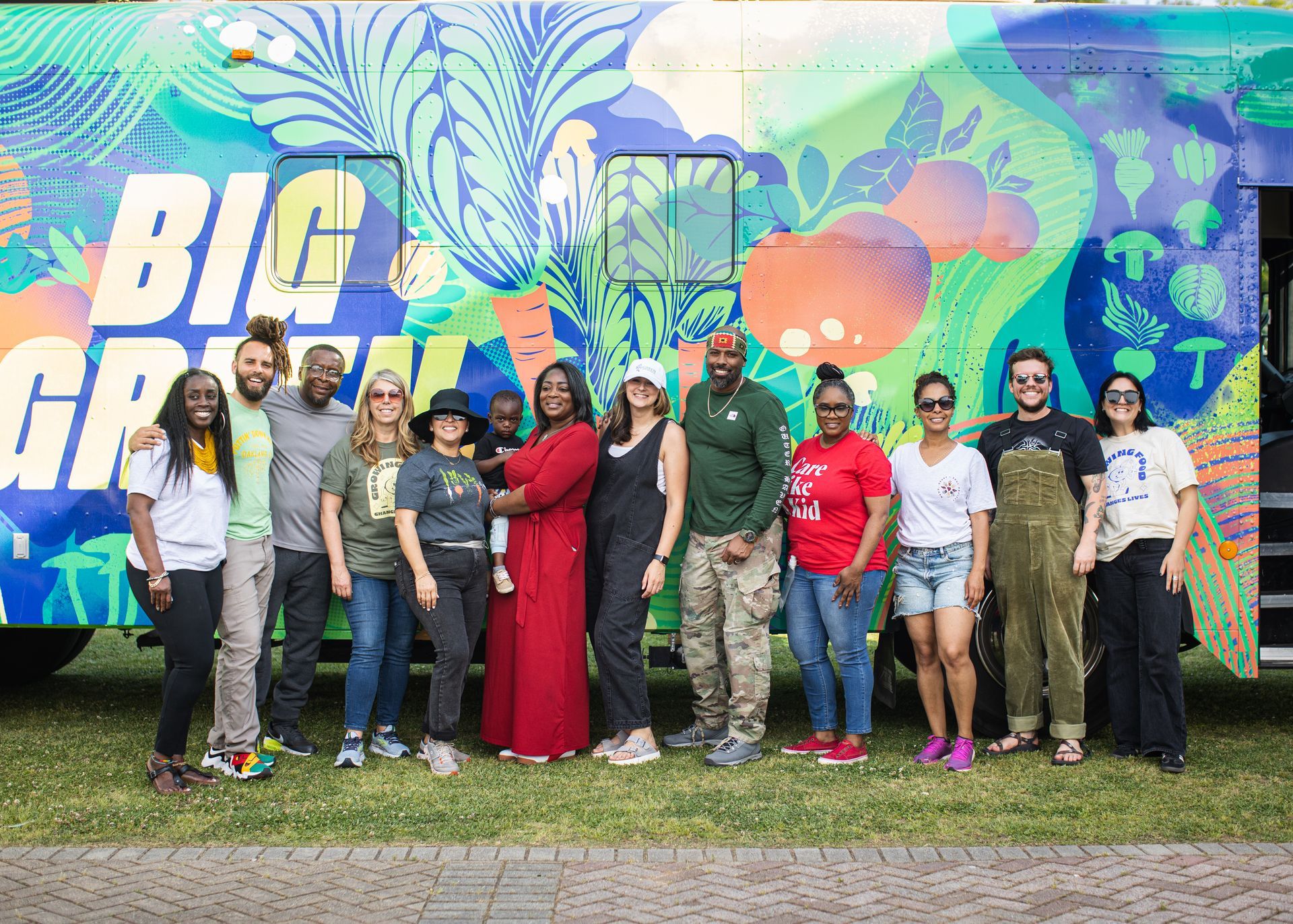 A group of people are posing for a picture in front of a food truck.