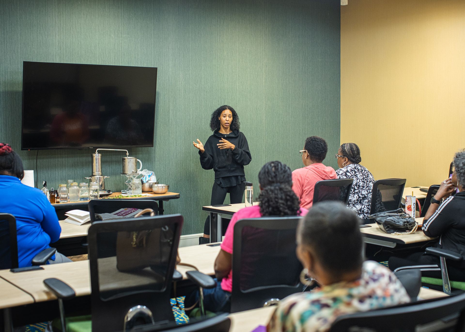 A woman is giving a presentation to a group of people in a classroom.