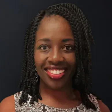A woman with braids is smiling for the camera.