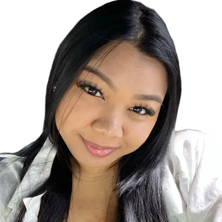 A woman with long black hair is smiling and wearing a white shirt.