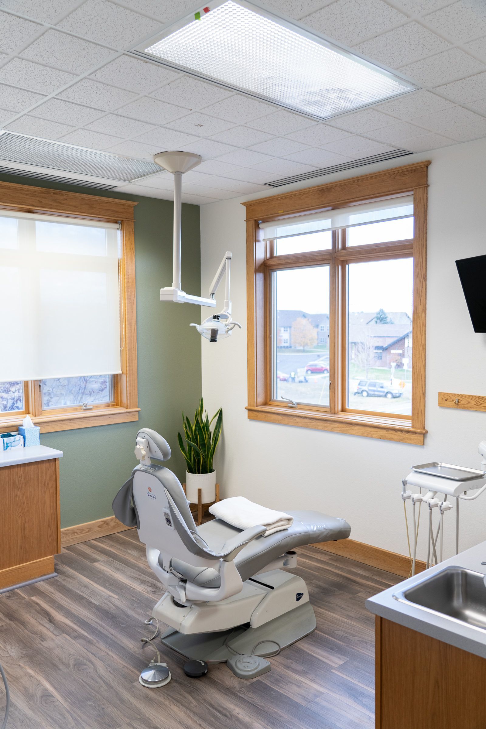 A dental office with a dental chair and a sink.