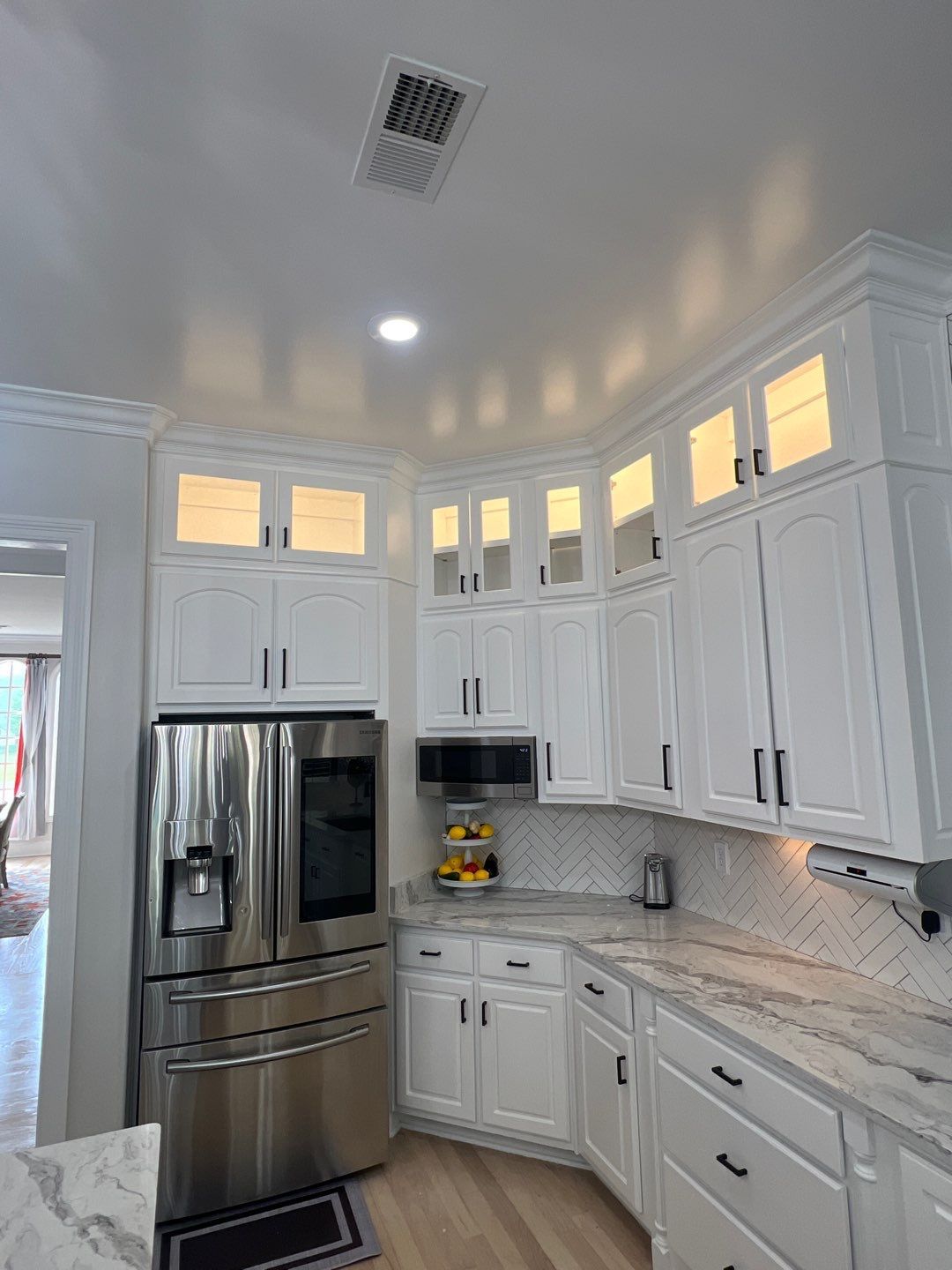 A kitchen with white cabinets and stainless steel appliances.