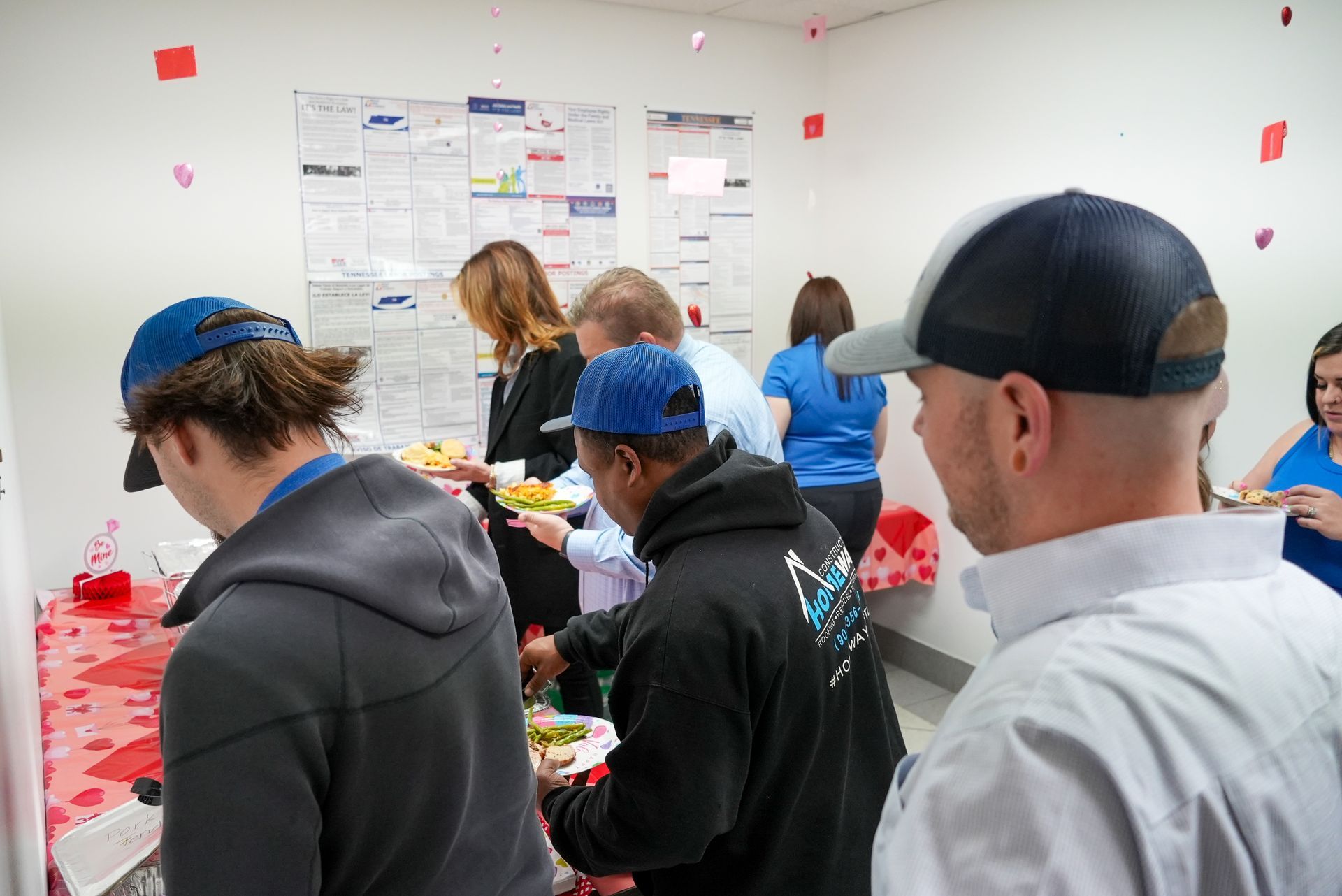 a man is kneeling down in a room next to a fan .