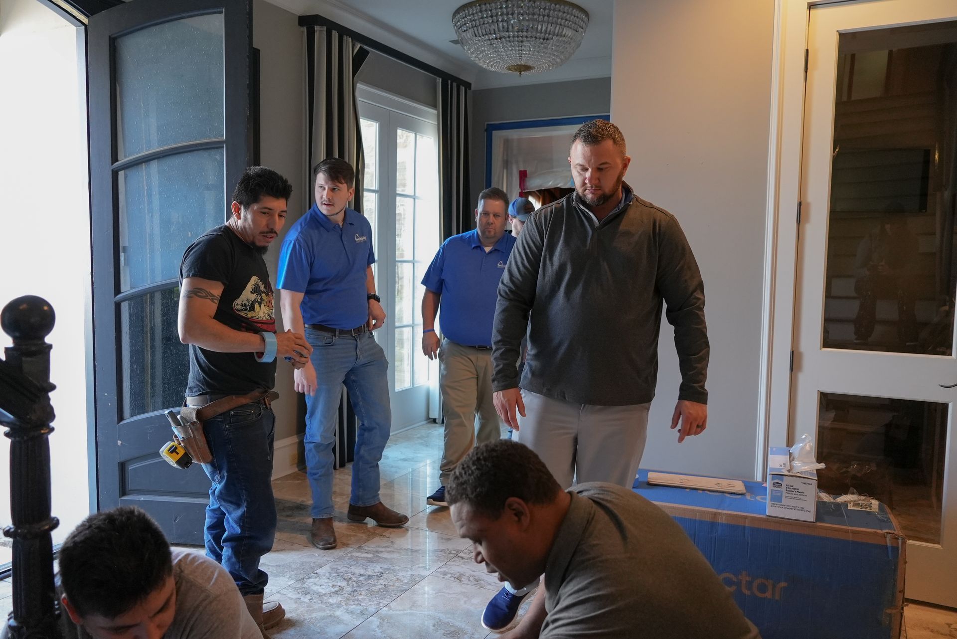 a man is carrying two red boxes in a room .