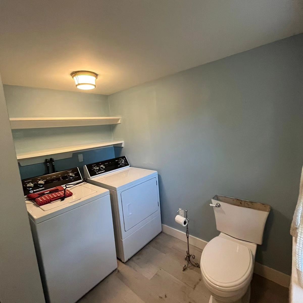 A laundry room with a washer and dryer and a toilet.