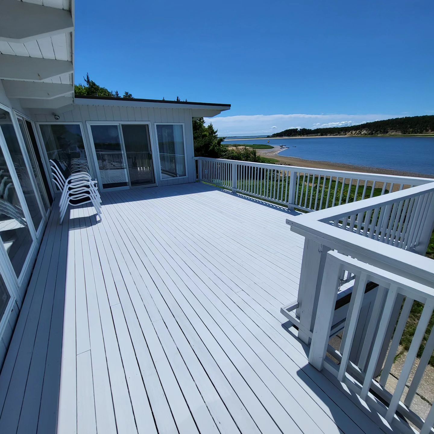 A white deck with a view of a body of water