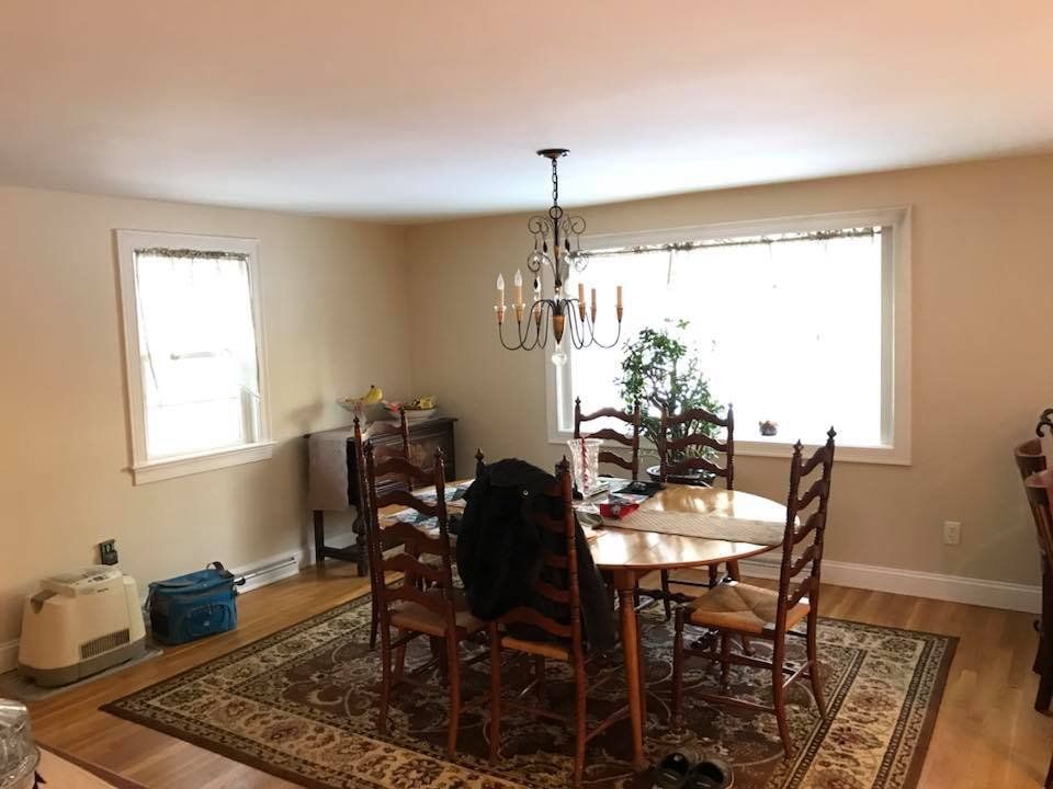 A dining room with a table and chairs and a chandelier.