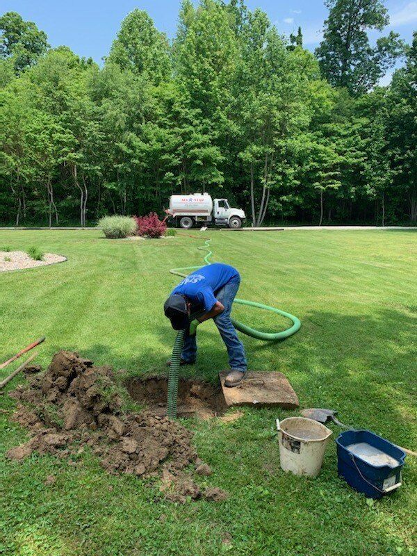 Man Putting Hose In Septic Frontside | Terre Haute, IN | All Star Sanitation Inc.