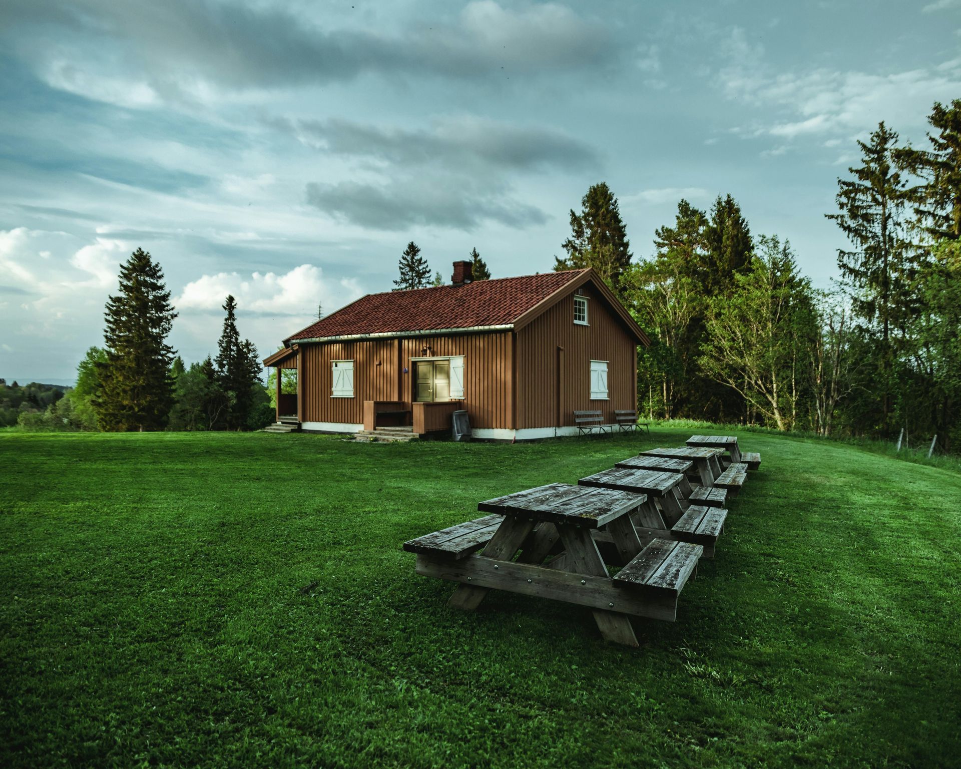 A wooden house with a picnic table in front of it.