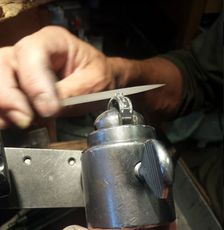 A person is sharpening a ring with a pair of scissors