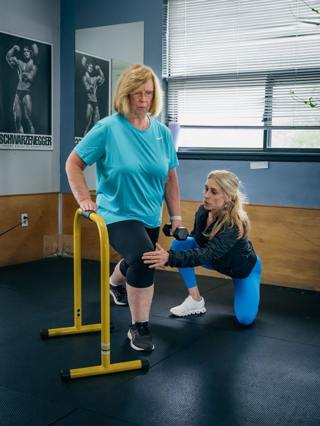 personal trainer showing how to weight lift at The Fitness Firm