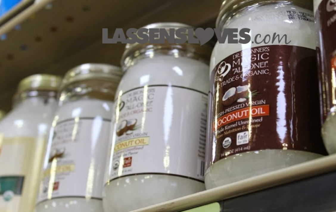 Glass jars of coconut oil on a shelf, with white oil visible.