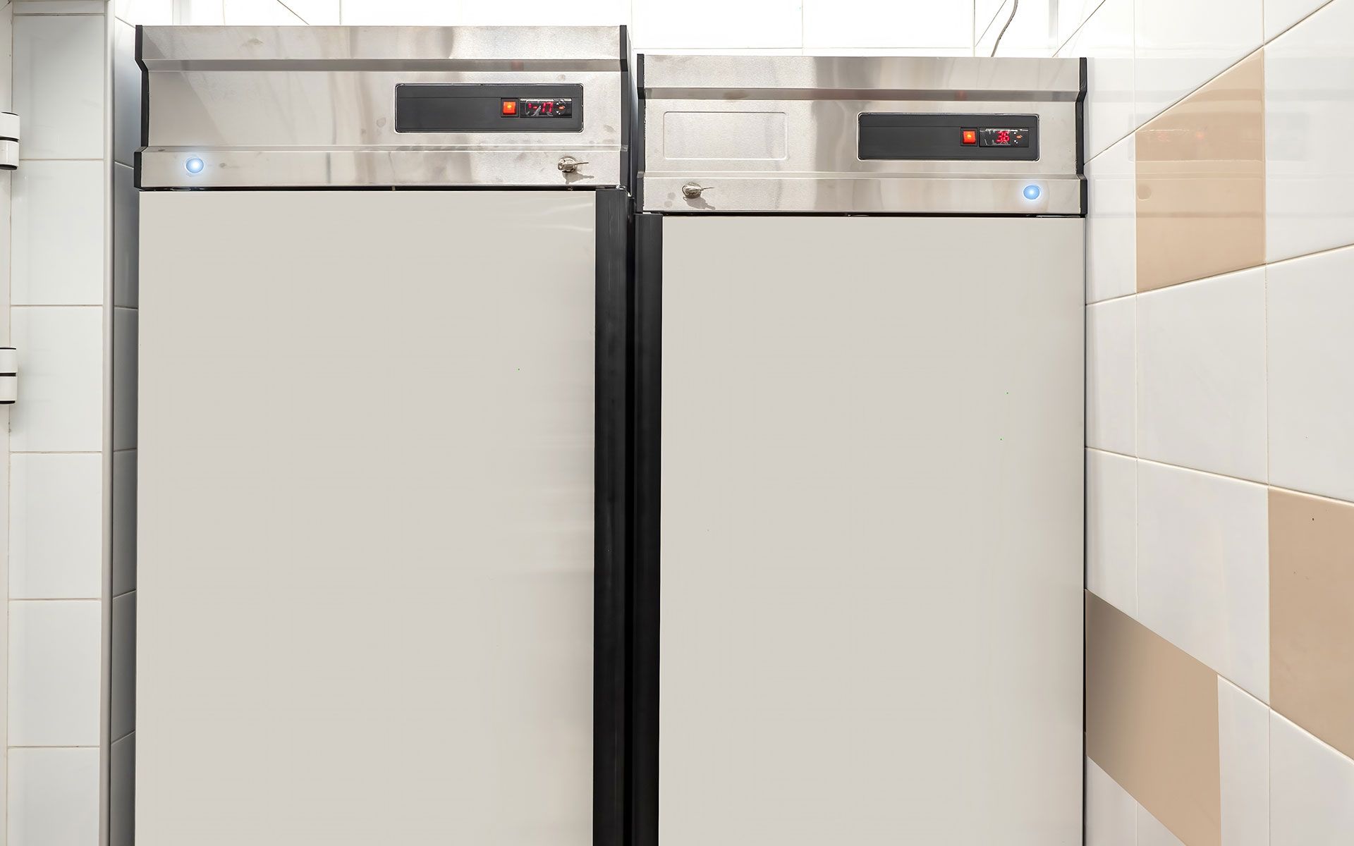 Two refrigerators are sitting next to each other in a kitchen.