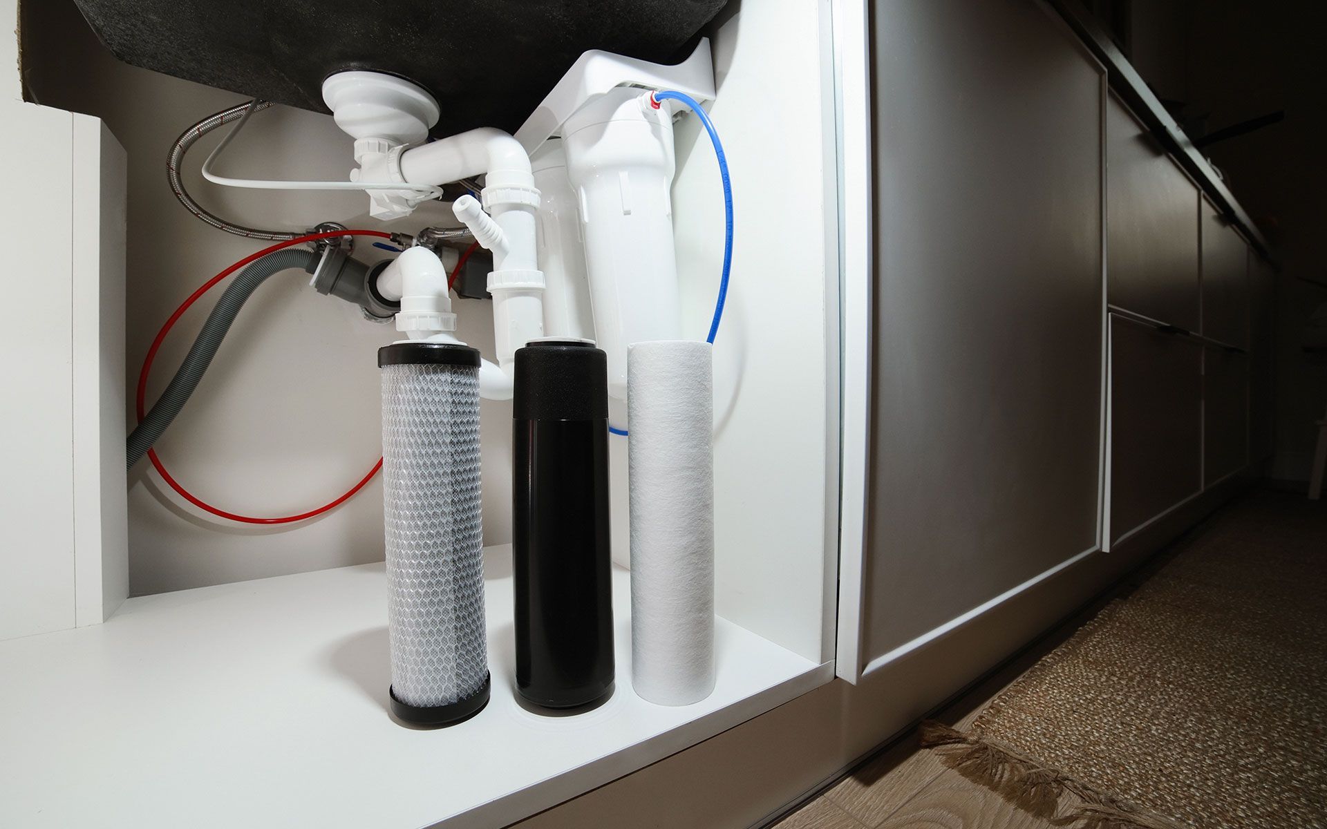 A kitchen sink with a water filter underneath it.