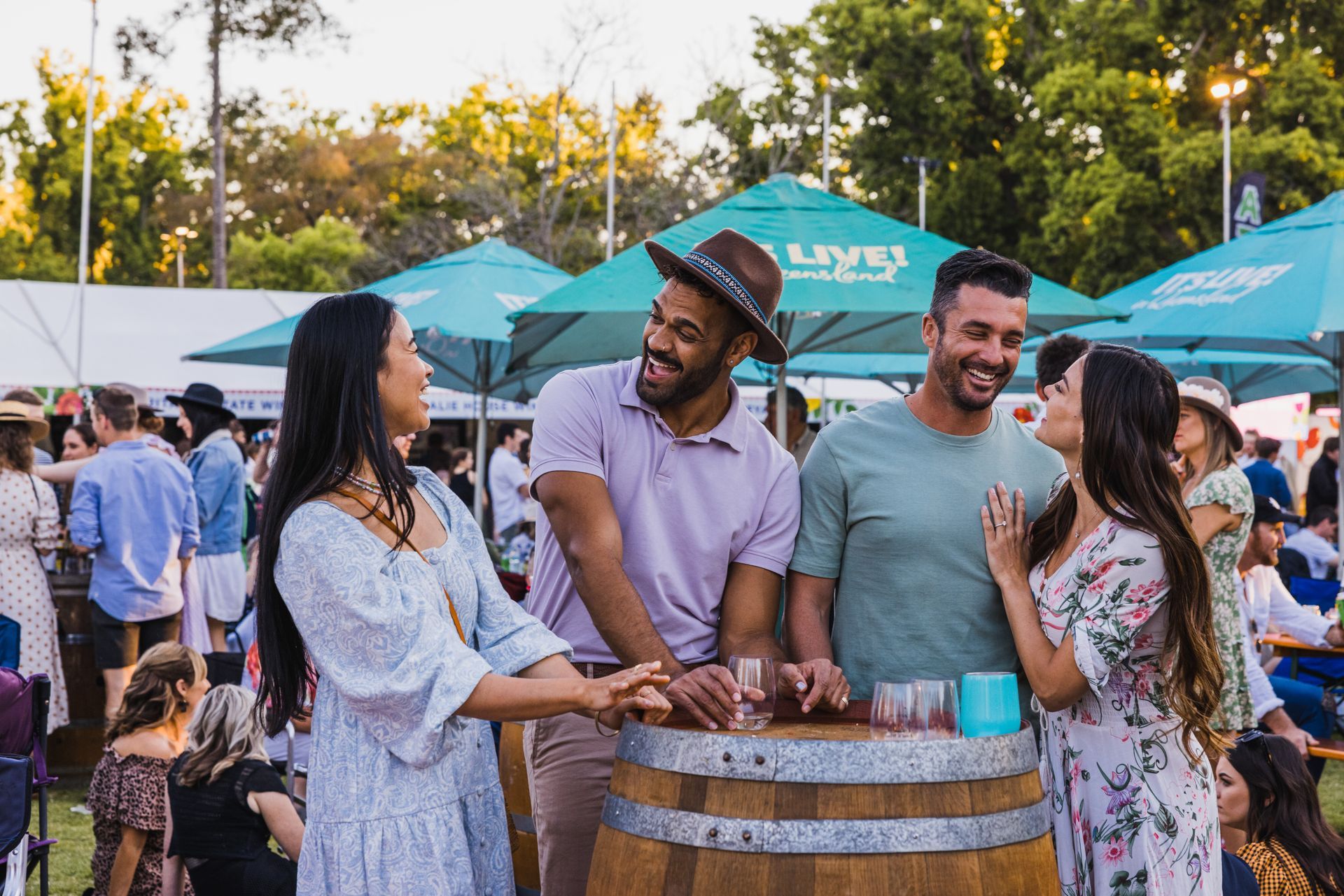 A group of people are standing around a wooden barrel at a festival.