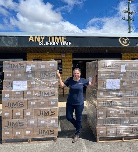 A woman stands in front of a building that says any time is jerky time.