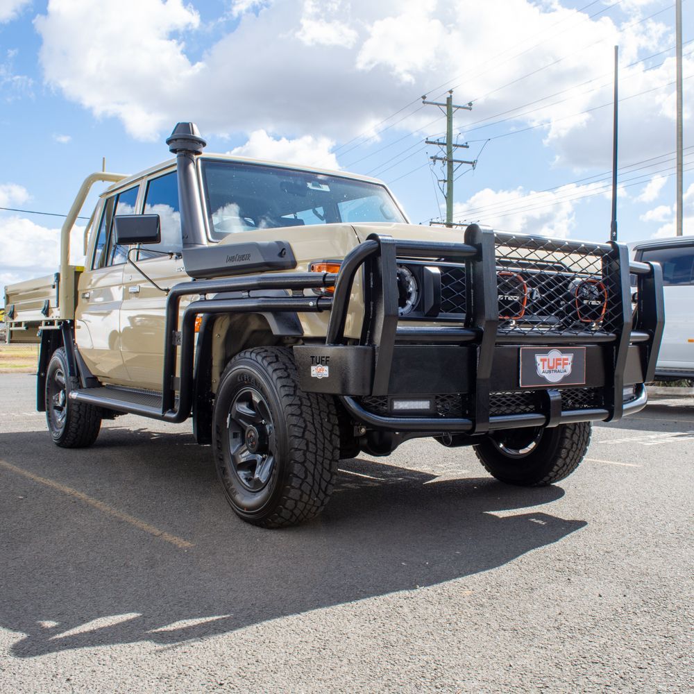 A truck is parked in a parking lot with a tuff logo on the front bumper.