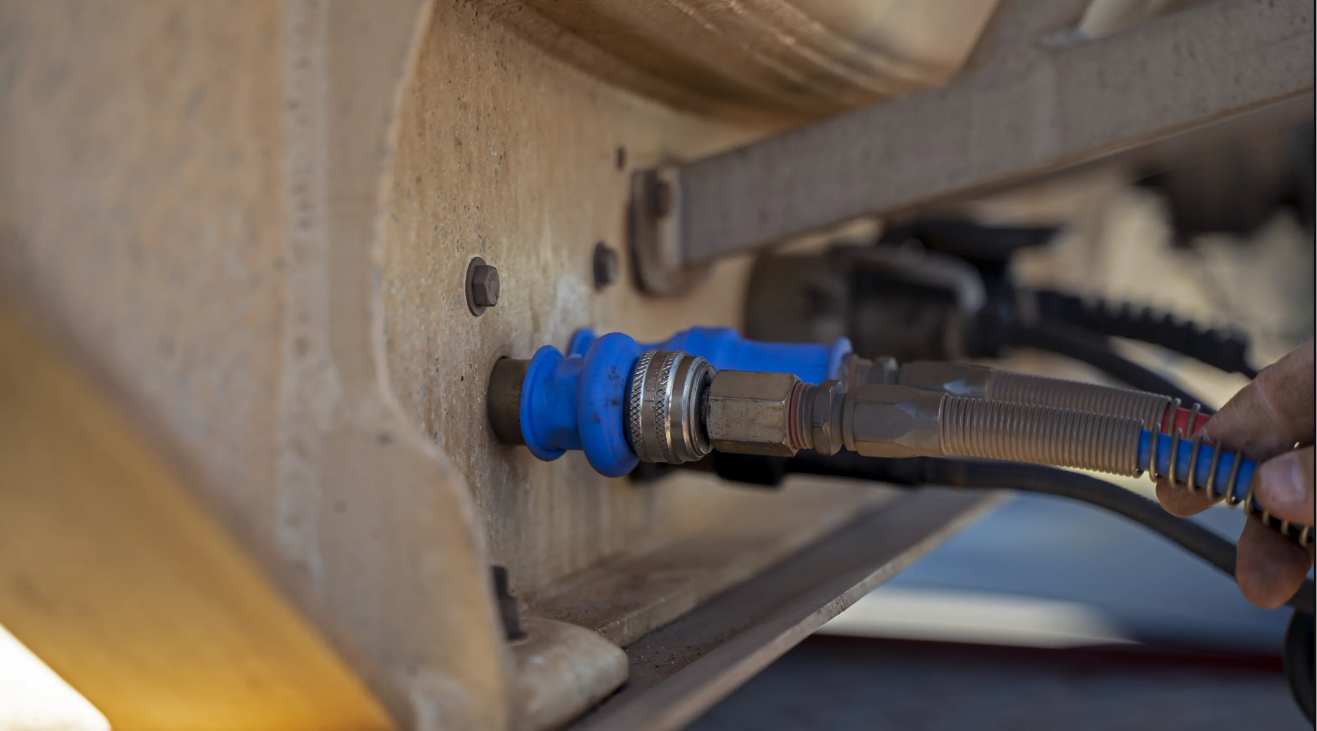 A person is plugging a hose into a machine.