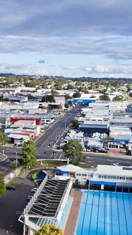 An aerial view of a city with a swimming pool in the middle of it.