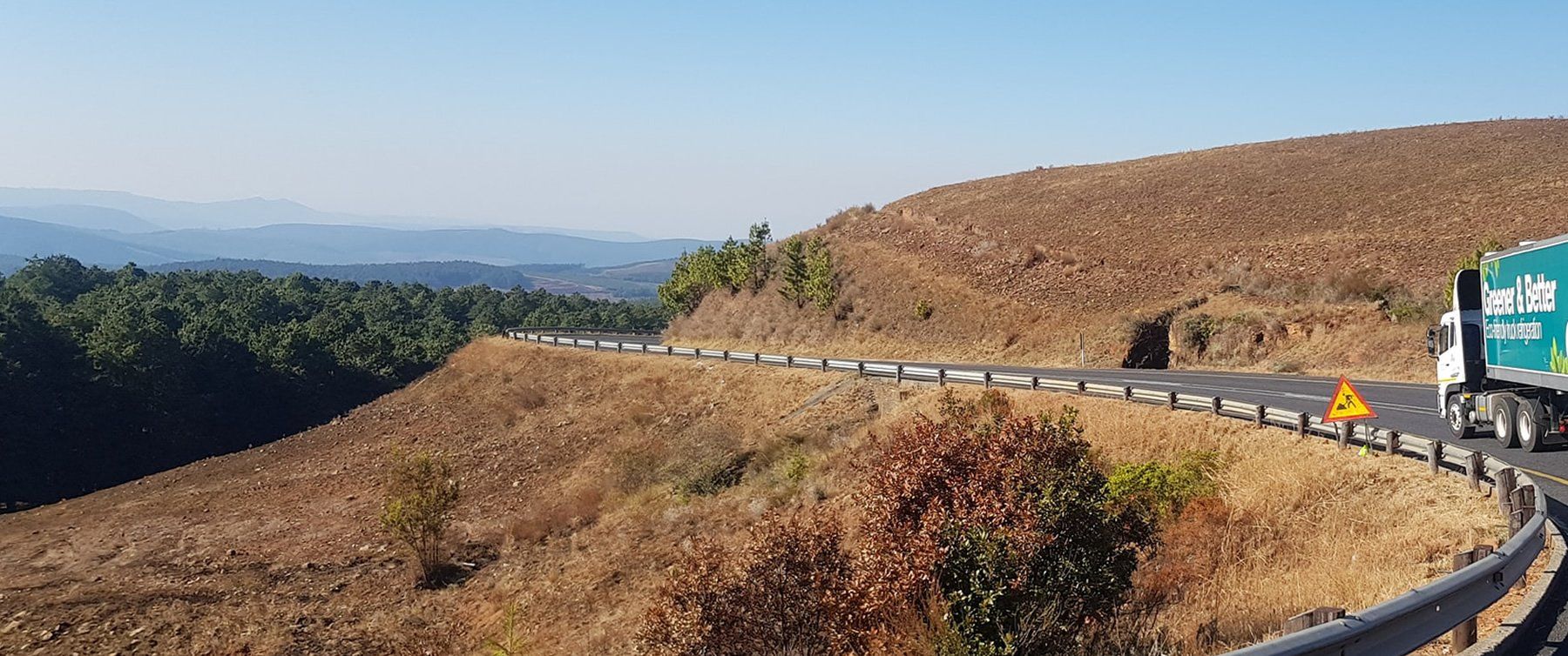 A truck is driving down a curvy mountain road.